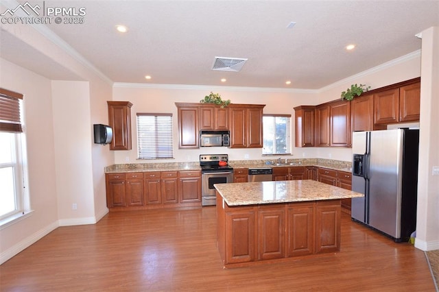 kitchen featuring stainless steel appliances, a wealth of natural light, and a kitchen island