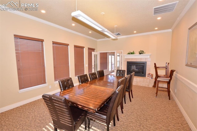 carpeted dining room featuring a fireplace and crown molding