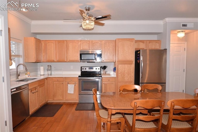 kitchen with stainless steel appliances, light brown cabinetry, light hardwood / wood-style floors, ornamental molding, and sink