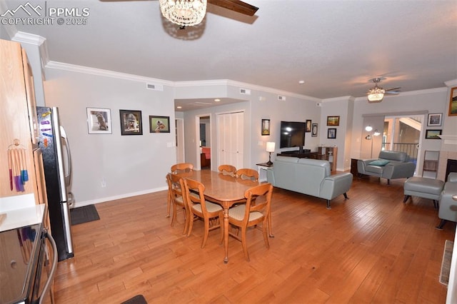 dining room with ceiling fan, light wood-type flooring, and crown molding