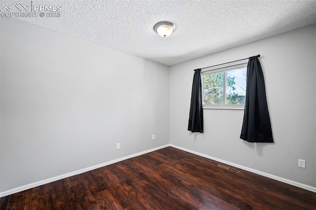 empty room with a textured ceiling and hardwood / wood-style floors