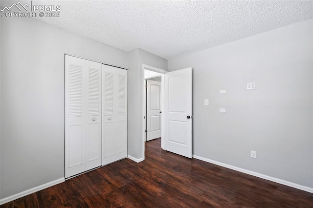 unfurnished bedroom with a closet, a textured ceiling, and dark hardwood / wood-style floors