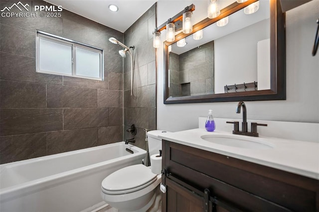 full bathroom featuring toilet, vanity, and tiled shower / bath