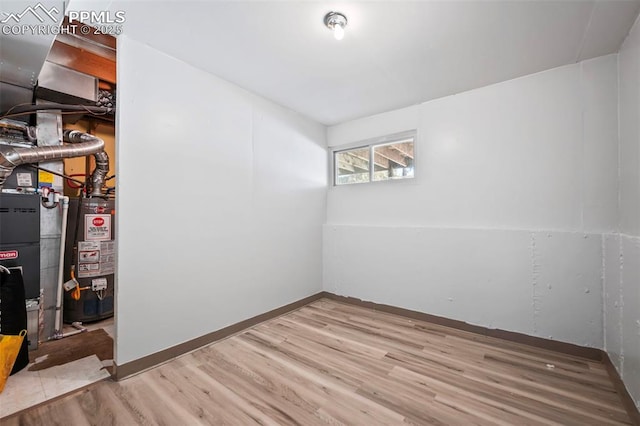 basement with light wood-type flooring and gas water heater