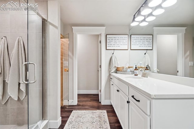 bathroom with hardwood / wood-style floors, a shower with door, and vanity