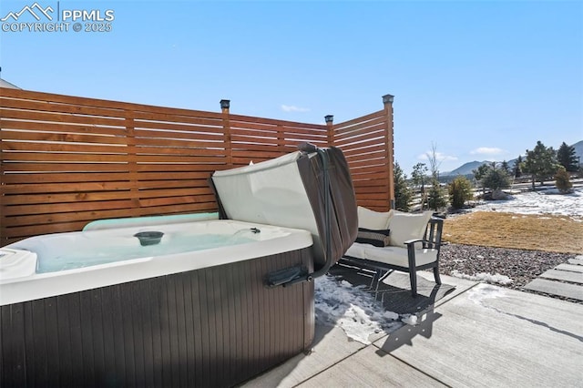 snow covered patio featuring a hot tub