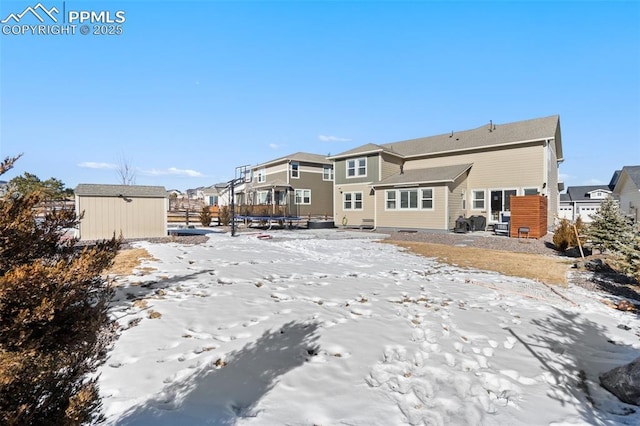 snow covered property with a storage unit