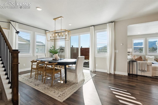 dining room featuring dark hardwood / wood-style flooring, an inviting chandelier, and a wealth of natural light