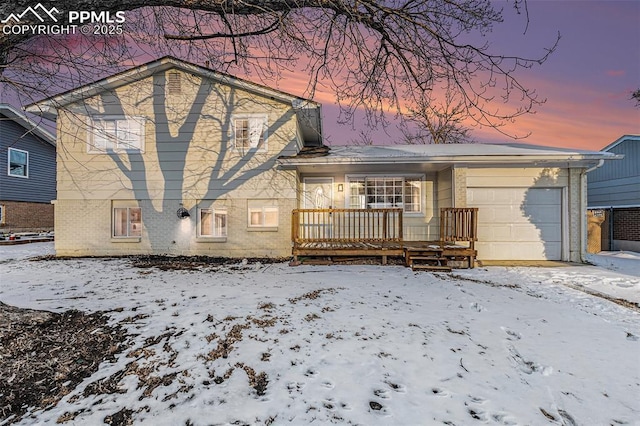 snow covered back of property featuring a garage and a porch