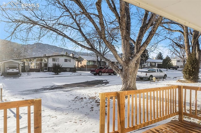 snowy yard featuring a deck with mountain view