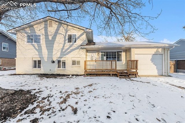 snow covered back of property with a garage and covered porch