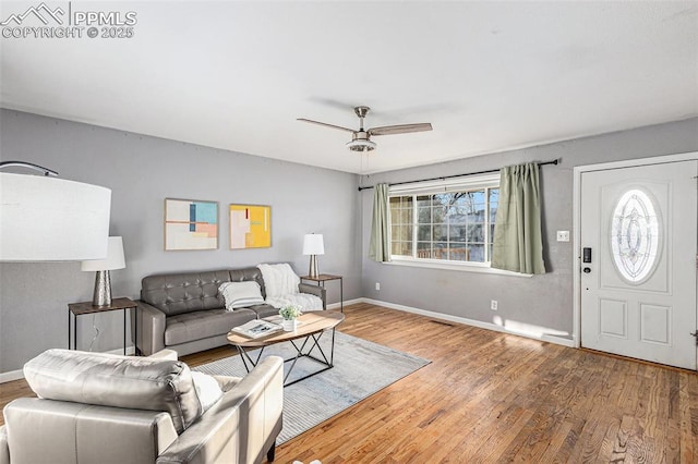 living room with wood-type flooring and ceiling fan