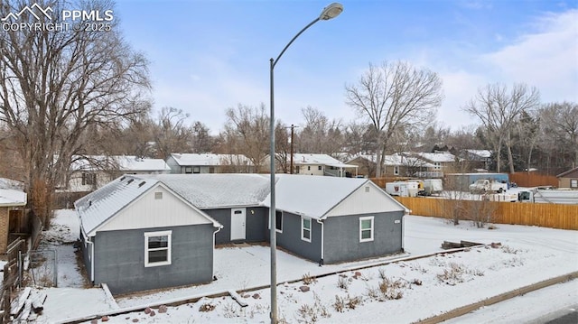 view of snow covered back of property