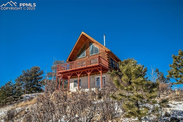 snow covered house featuring a deck