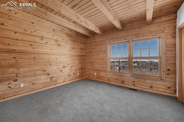 carpeted spare room with wooden ceiling, wood walls, and beam ceiling