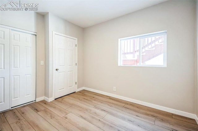 unfurnished bedroom with light hardwood / wood-style flooring and a closet