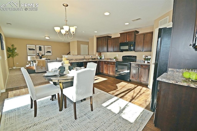 dining room with an inviting chandelier, sink, and light hardwood / wood-style floors