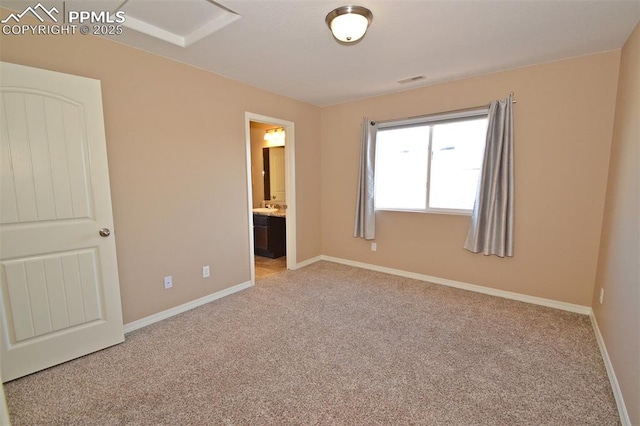 unfurnished bedroom with light carpet and ensuite bath