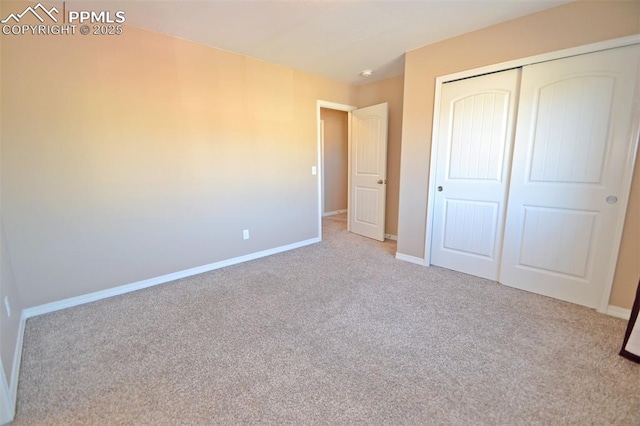 unfurnished bedroom featuring light carpet and a closet