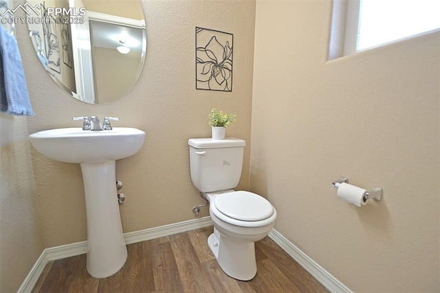 bathroom with hardwood / wood-style floors, sink, and toilet