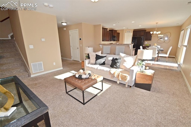 carpeted living room with a notable chandelier