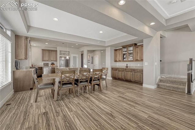 dining space featuring a tray ceiling and hardwood / wood-style floors