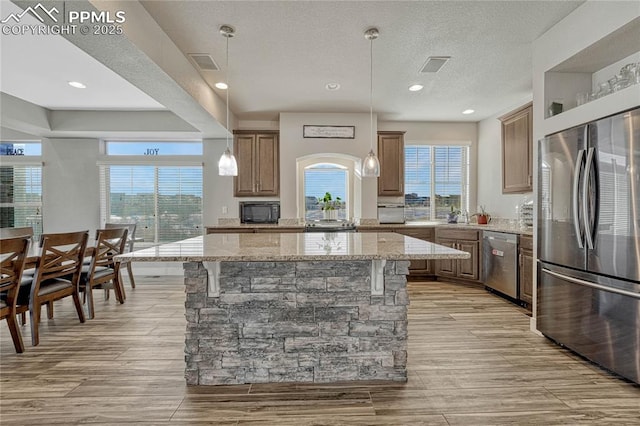 kitchen featuring appliances with stainless steel finishes, a kitchen breakfast bar, and a center island