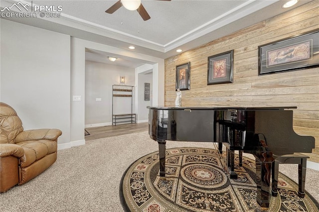 miscellaneous room featuring carpet floors, ceiling fan, and wood walls