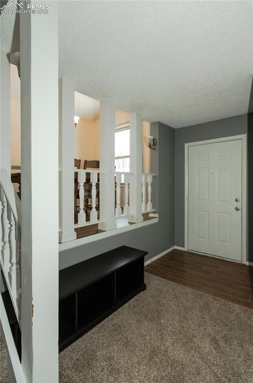 entryway with carpet flooring and a textured ceiling