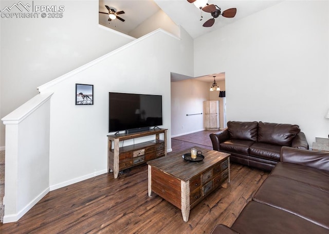 living room featuring ceiling fan with notable chandelier, dark wood-type flooring, and high vaulted ceiling