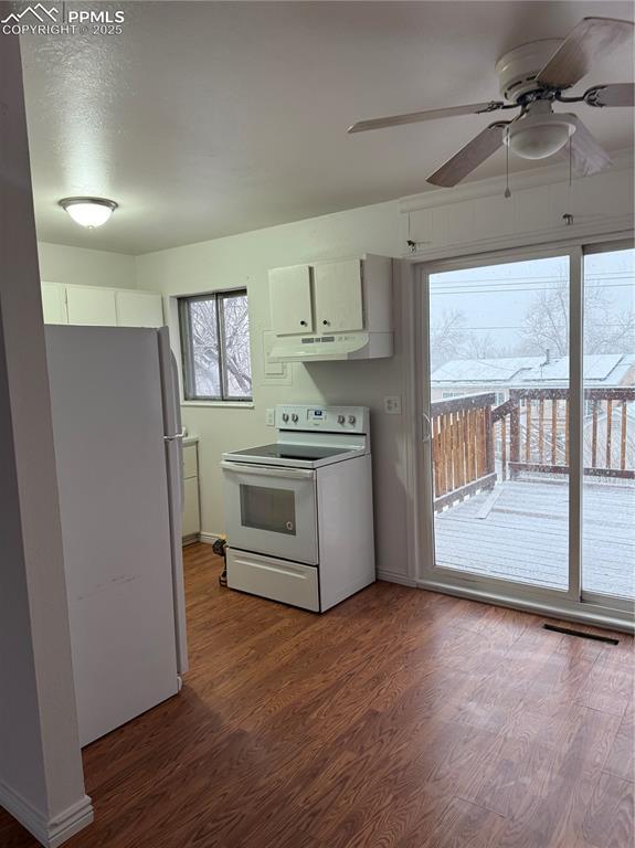 kitchen featuring white appliances, white cabinets, ceiling fan, and hardwood / wood-style flooring