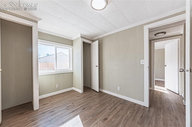 unfurnished bedroom with wood-type flooring, a textured ceiling, and crown molding