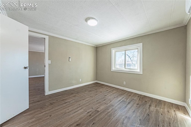 spare room with a textured ceiling, crown molding, and wood-type flooring