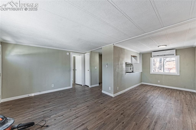 interior space with a wall unit AC, a textured ceiling, sink, and dark hardwood / wood-style floors