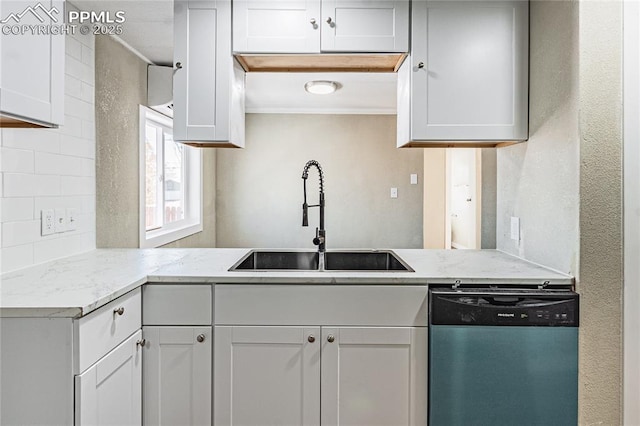 kitchen with light stone counters, white cabinets, dishwasher, and sink