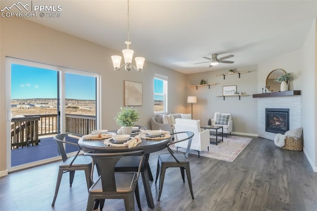 dining room with dark hardwood / wood-style flooring and ceiling fan with notable chandelier