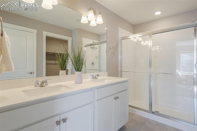 bathroom featuring a shower with shower door, tile patterned floors, and vanity