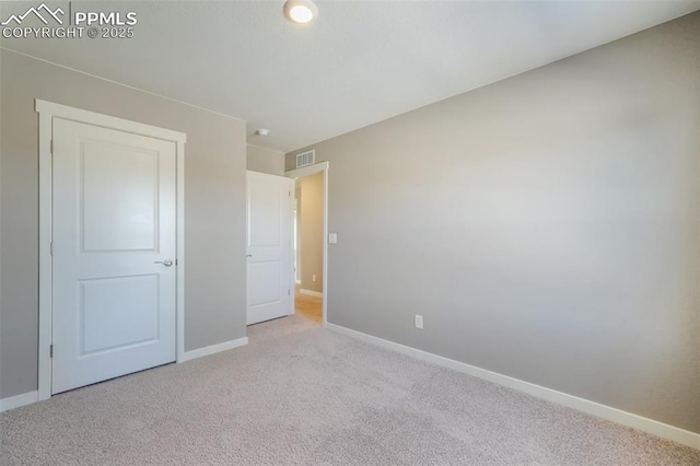 unfurnished bedroom featuring light carpet