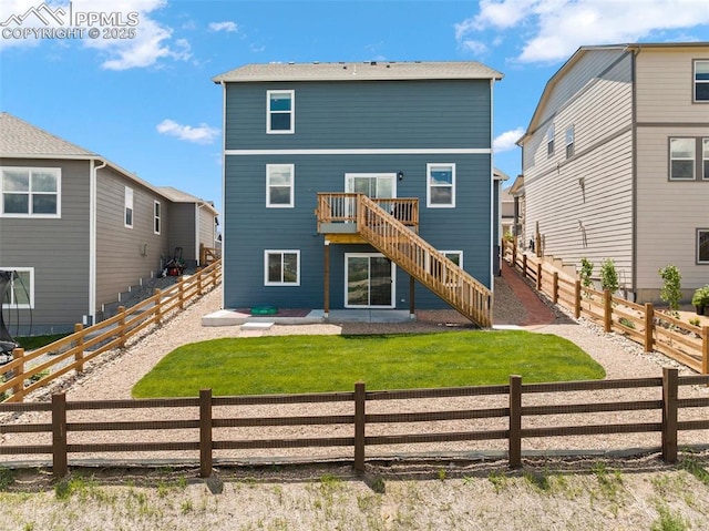 rear view of property featuring a wooden deck and a lawn