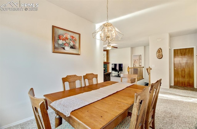 dining area with ceiling fan, light colored carpet, and a fireplace