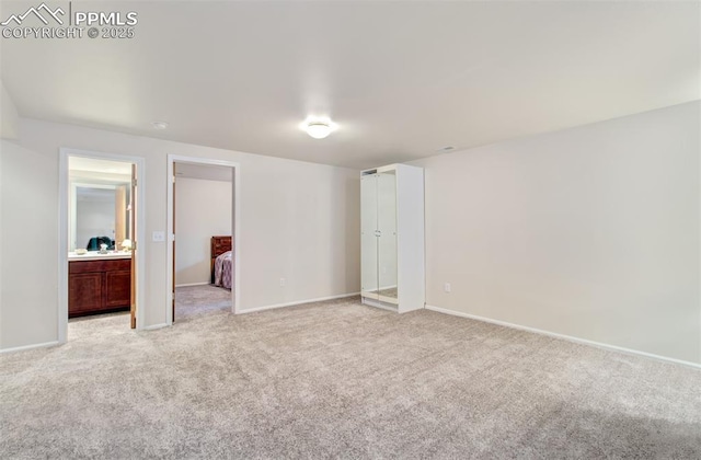 unfurnished bedroom featuring light colored carpet and ensuite bathroom