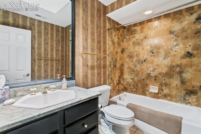 full bathroom featuring vanity, toilet, tiled shower / bath combo, and tile patterned flooring