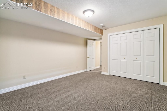 unfurnished bedroom with carpet, a textured ceiling, and a closet