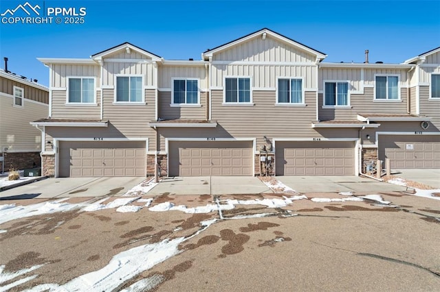 multi unit property featuring an attached garage, stone siding, board and batten siding, and concrete driveway