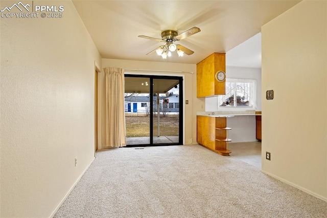 unfurnished living room with light colored carpet and ceiling fan