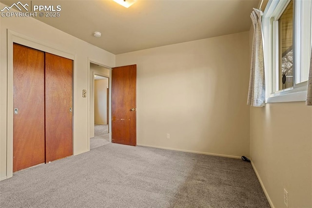 unfurnished bedroom with light carpet and a closet