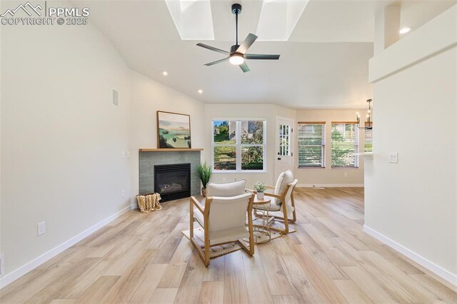 living room with ceiling fan, lofted ceiling, and light hardwood / wood-style flooring