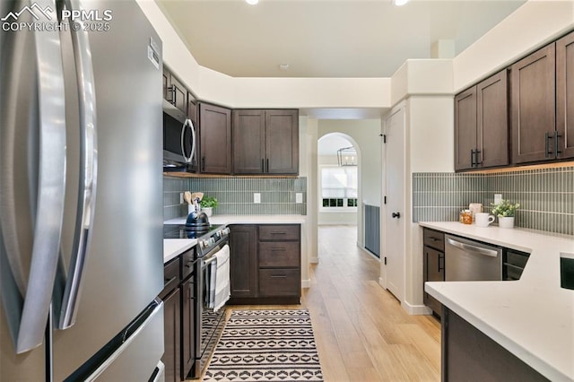 kitchen with appliances with stainless steel finishes, light hardwood / wood-style floors, and dark brown cabinetry