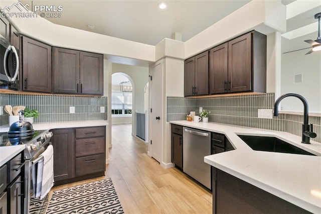 kitchen with stainless steel appliances, dark brown cabinets, and sink