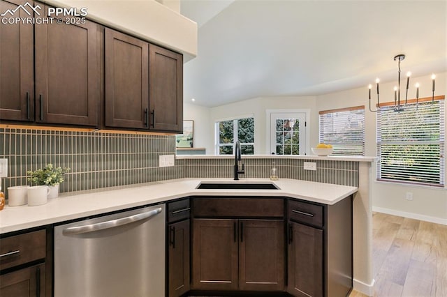 kitchen with light hardwood / wood-style floors, decorative backsplash, dark brown cabinets, dishwasher, and sink